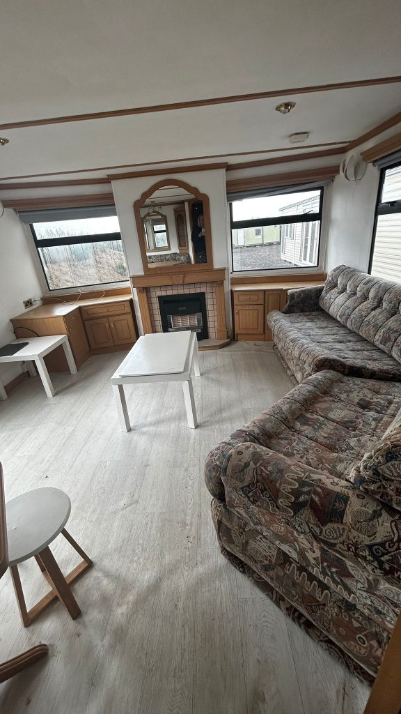 fireplace with mirror and two sofas in lounge Static Caravan.