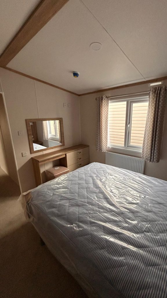 double bed and vanity table with mirror on wall
